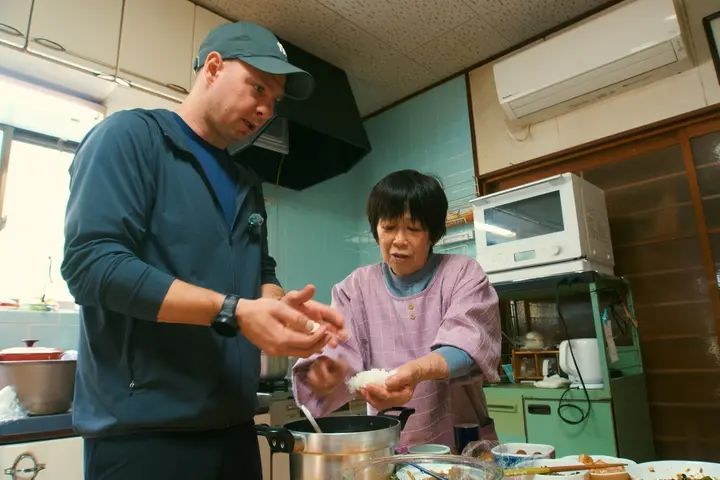 Jason shaping onigiri with a Japanese grandmother