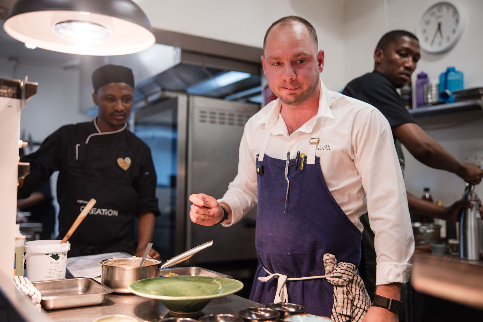 Chef Jason McKinney plating a dish during service at Creation Wines