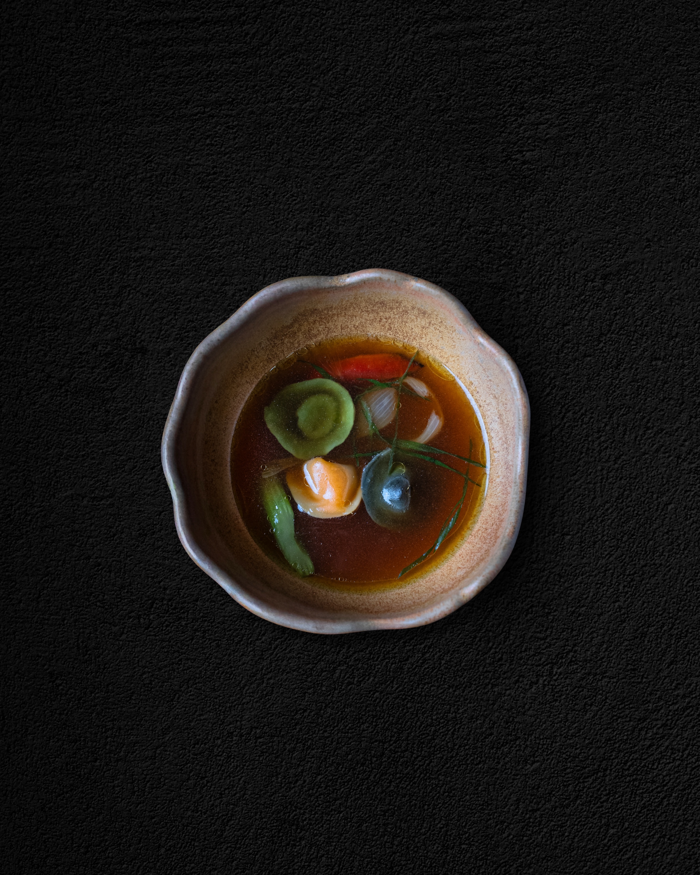 A composed dish in a textured ceramic bowl