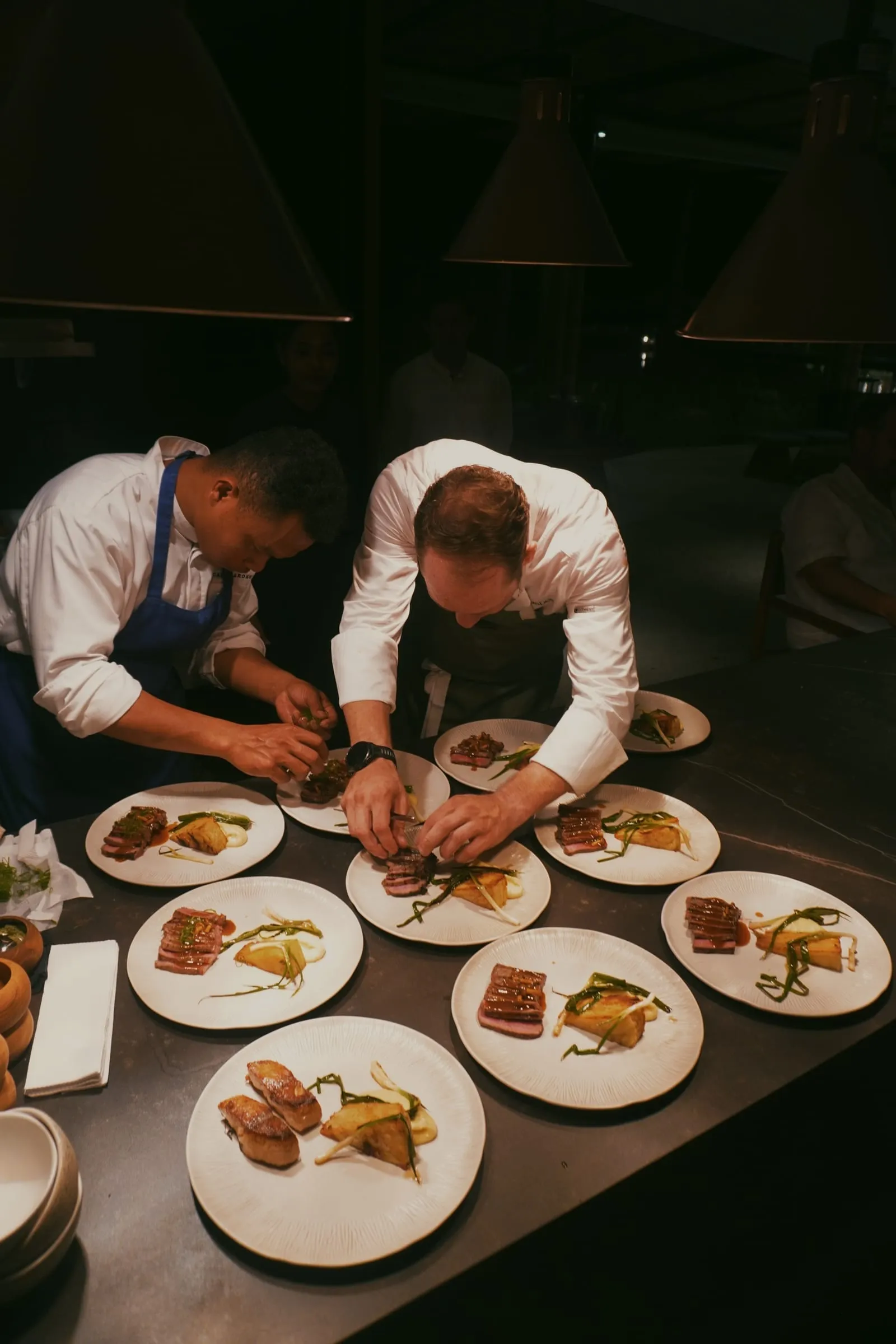 Chef Jason McKinney plating alongside a chef during service at Cap Karoso in Sumba