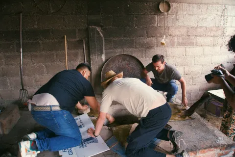 Preparing the covered pit for traditional barbacoa in Mexico