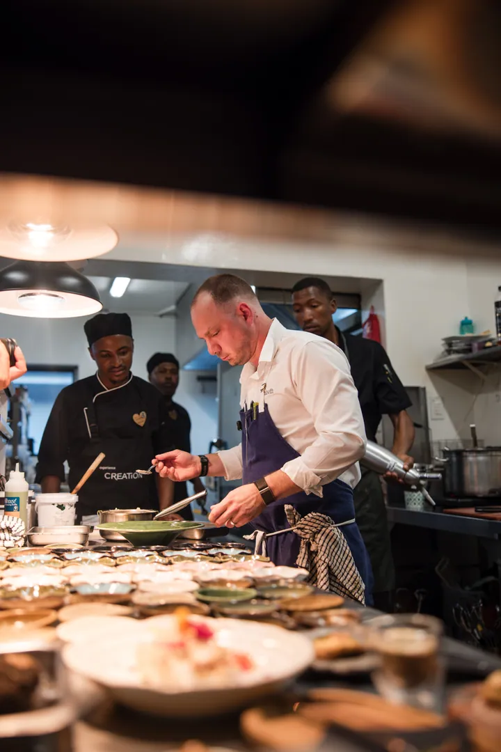 Jason cooking at the pass with the Creation Wines kitchen team
