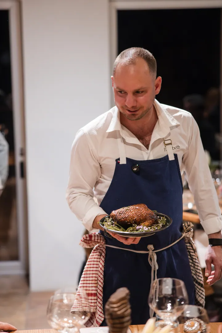 Jason carrying roast duck through the Creation Wines dining room