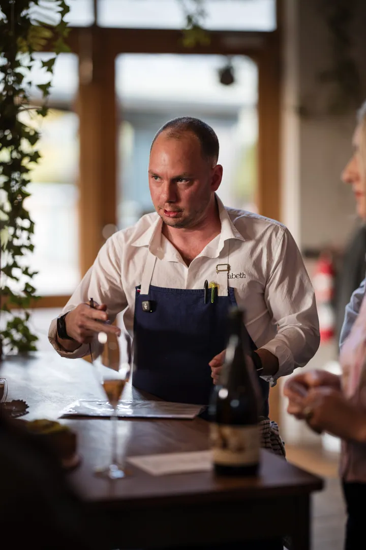 Jason speaking beside a bottle of wine during dinner at Creation Wines