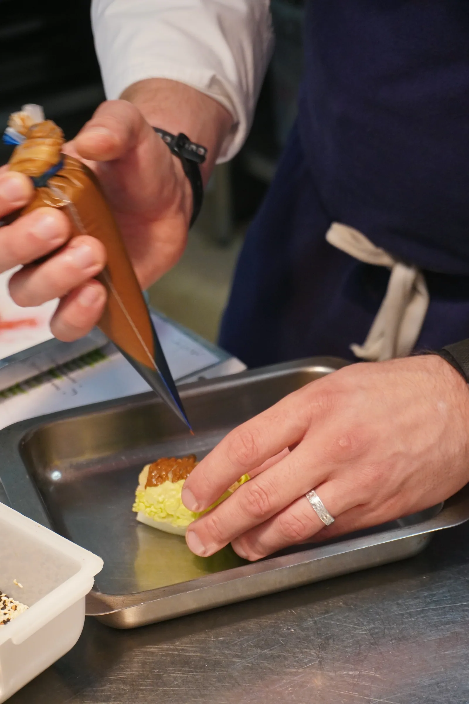 Jason piping onto a dish during prep at Creation Wines