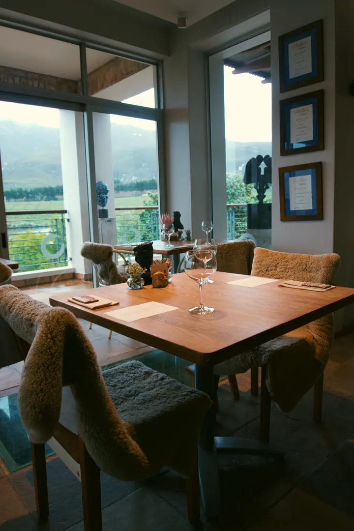 A table set beside the windows overlooking Creation’s vineyard