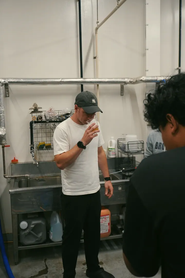A visitor smelling a cup during a tasting inside the tea factory