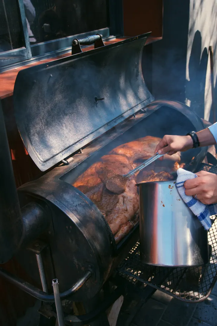 Meat cooking over the smoky outdoor grill at Kruger Shalati