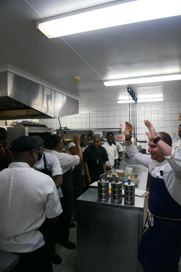 Jason and the kitchen team raising their hands together at Kruger Shalati
