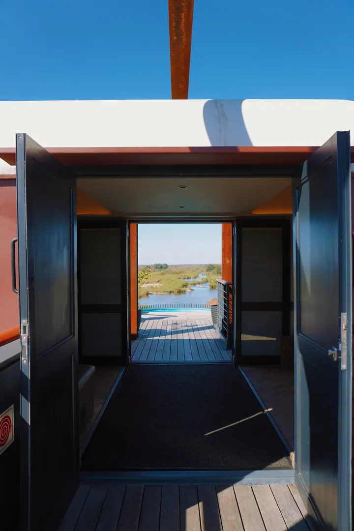 The doorway of a Kruger Shalati train suite looking through to the view beyond
