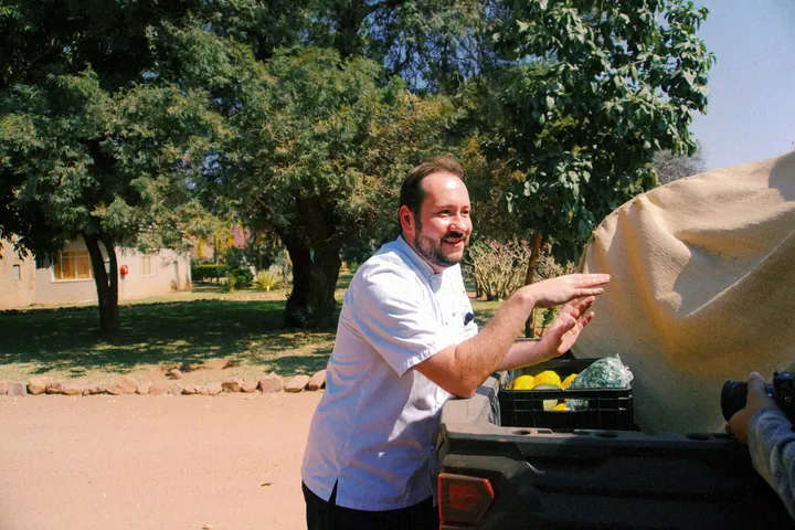 Jason holding dough beside an outdoor pizza oven at Few & Far